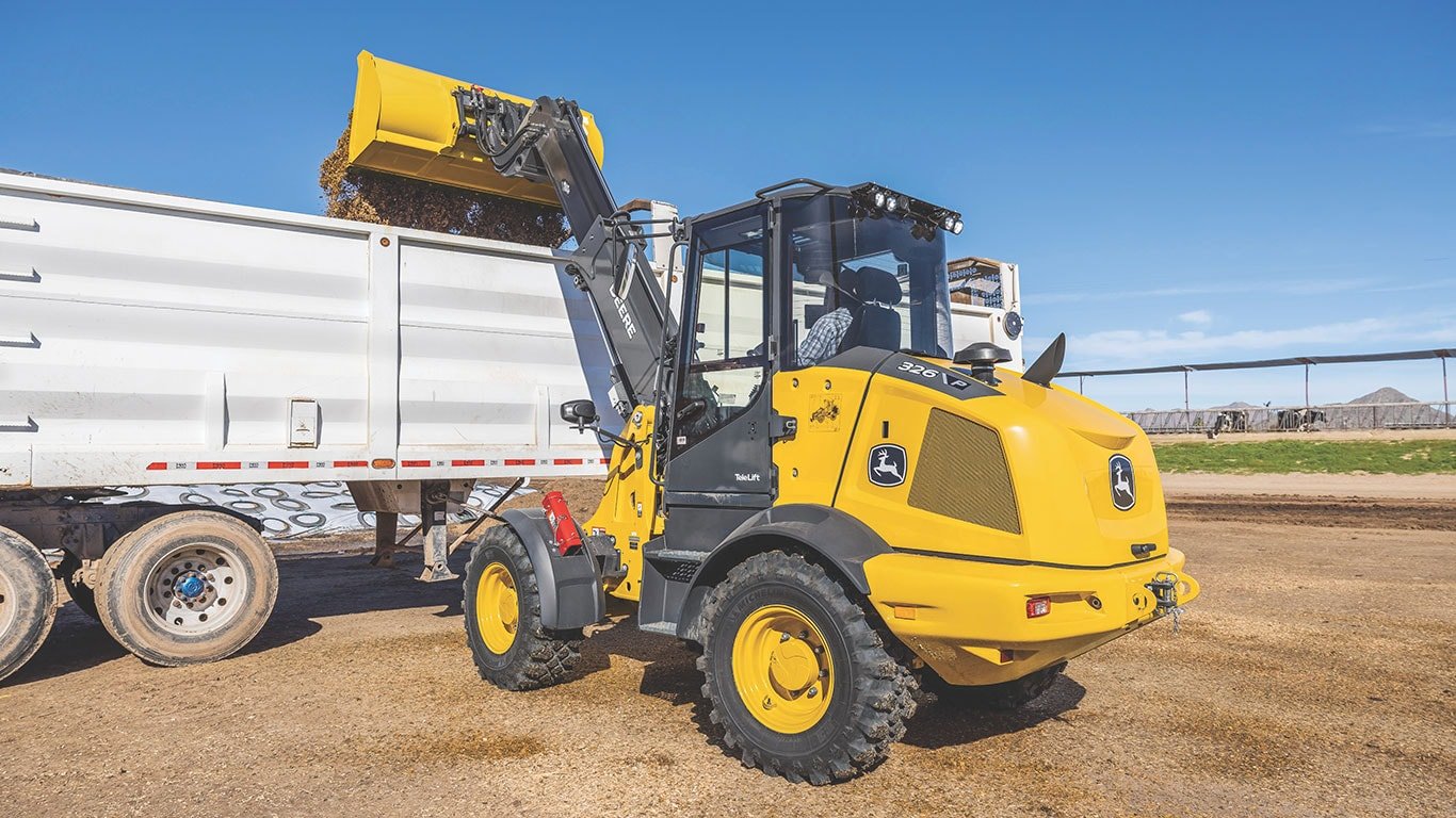 The John&nbsp;Deere 326 P-Tier Telescopic Loader dumping dirt into a truck